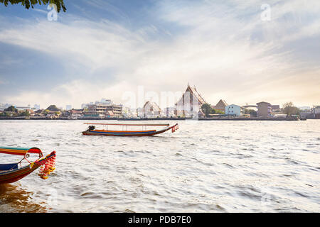 Traditionelle Thai Long tail Boot im Chao Phraya River in der Nähe von Wat Arun bei Sonnenuntergang in Bangkok, Thailand Stockfoto