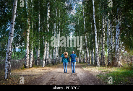 Glückliches Paar in Karo-hemden auf der Straße in Birke in Kirgisistan. Romantisches date im Wald. Stockfoto