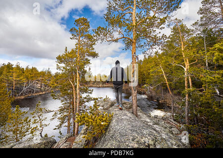 Mann in Schwarz Jacke zu Fuß zu den schönen See im Wald von Karkaraly Saytankol National Park im Zentrum von Kasachstan Stockfoto