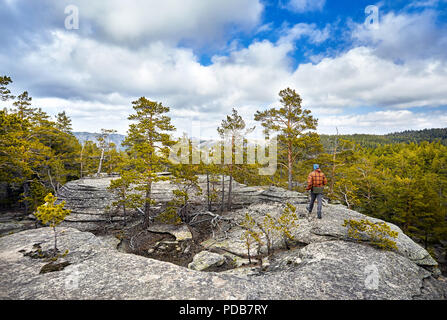 Mann in der braunen Jacke zu Fuß zu den wunderschönen Wald in Karkaraly Nationalpark in Karkaralinsk, zentrale Kasachstan Stockfoto