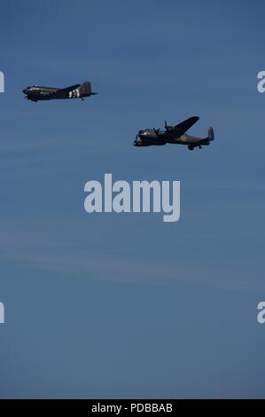 Dakota und Lancaster Flugzeuge fliegen in die Schlacht um England Memorial Flight, Torbay Airshow 2018. Devon, UK. Stockfoto