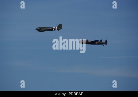 Dakota und Lancaster Flugzeuge fliegen in die Schlacht um England Memorial Flight, Torbay Airshow 2018. Devon, UK. Stockfoto