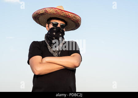 Junge männliche Person verkleidet als Gangster in den traditionellen Sombrero, Bandana. Mexikanische festliche oder Halloween Konzept des Menschen als Bandit oder westlichen sty Posing Stockfoto