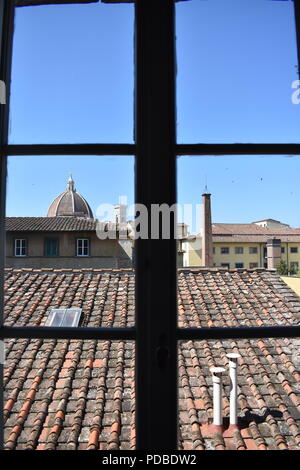 Blick auf die Skyline von Florenz und den Dom durch das Fenster mit der Silhouette eines Fensters mit Blick auf die Terrakotta Dächer Stockfoto