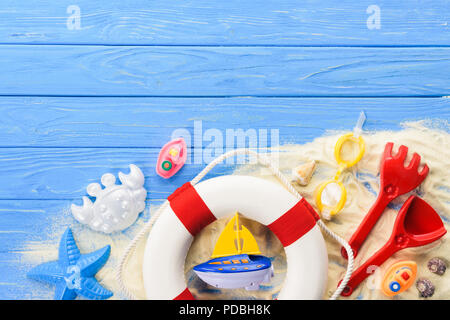 Leben Ring und Strandspielzeug auf Blau Holz- Hintergrund Stockfoto