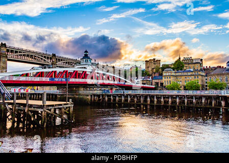 Blick auf den Fluss Tyne in Richtung Newcastle Schloss, Armstrongs swingbridge und der Hohen Eisenbahnbrücke bei Sonnenuntergang. Newcastle, UK. Stockfoto