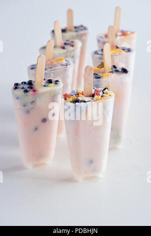 Gefrorenen hausgemachtes Eis am Stiel mit Bio Obst und Beeren auf Grau Stockfoto