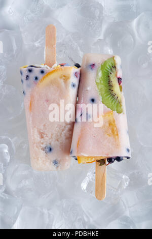 Blick von oben auf die köstliche hausgemachte Eis am Stiel mit Früchten und Beeren auf Eiswürfel Stockfoto