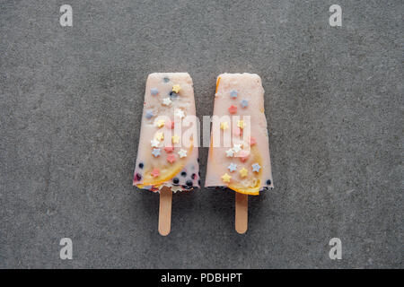 Blick von oben auf die süß lecker Eis am Stiel auf Sticks auf Grau Stockfoto