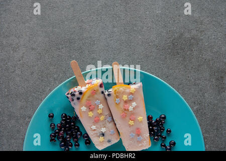 Blick von oben auf die süßen kalt Eis am Stiel mit Beeren auf Platte auf Grau Stockfoto
