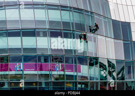 Zwei Fensterputzer arbeiten auf dem Sage, ein Wahrzeichen Konzerthalle in einem gebogenem Glas und Edelstahl Gebäude, das im Jahr 2004 eröffnete, Gateshead, Großbritannien. Stockfoto