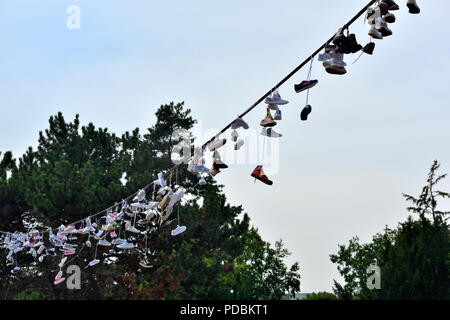 Schuhe und Stiefel hängen von einer Oberleitung Metronom in Prag, Tschechische Republik Stockfoto