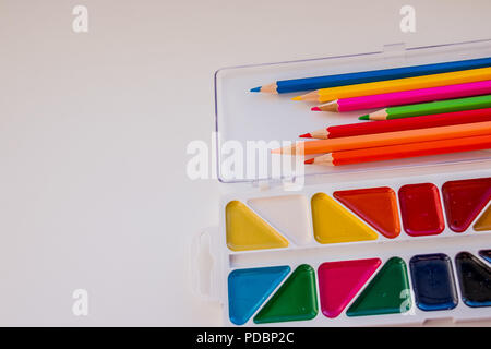 Schreibtisch Kid's mit bunten Stifte, Pinsel und Aquarellfarben, Ansicht von oben mit der Kopie Raum. Zurück zu Schule. Zeichnung liefert, sortierte Farben pencils.education frame-Konzept. Stockfoto