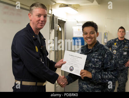 NEWPORT NEWS, Virginia (Aug. 3, 2018) Kulinarische Specialist Seaman Marissa Hodge, aus Denver, auf USS Gerald R. Ford's (CVN 78) Versorgung der Abteilung zugewiesen, erhält ein Zertifikat der Graduierung von Lt.Cmdr. Fred Masten, Sicherheit Ford's Officer, während eine in-port security Force (ISF) Klasse Graduierung. 20 - Neun Matrosen Graduierte der dreiwöchigen ISF-Kurs. (U.S. Marine Foto von Mass Communication Specialist 2. Klasse Katze Campbell) (Dieses Bild hat durch die Unschärfe personenbezogenen Daten für Zwecke der Sicherheit geändert wurde) Stockfoto