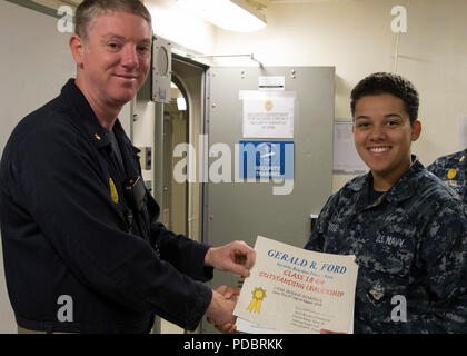 NEWPORT NEWS, Virginia (Aug. 3, 2018) Kulinarische Specialist Seaman Marissa Hodge, aus Denver, auf USS Gerald R. Ford's (CVN 78) Versorgung der Abteilung zugewiesen, erhält eine "hervorragende Führung" Award von Lt.Cmdr. Fred Masten, Sicherheit Ford's Officer, während eine in-port security Force (ISF) Klasse Graduierung. 20 - Neun Matrosen Graduierte der dreiwöchigen ISF-Kurs. (U.S. Marine Foto von Mass Communication Specialist 2. Klasse Katze Campbell) Stockfoto