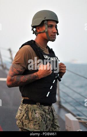 180806-N-ZS 023-1003 Straße von Hormuz (August 6, 2018) die Gunner Mate 2. Klasse Dante Johnson Watch steht als die geführte Anti-raketen-Zerstörer USS der Sullivans (DDG68) führt eine Routine Durchfahrt durch die Straße von Hormuz. Das Sullivans ist in die USA 5 Flotte Bereich der Maßnahmen zur Unterstützung der Marine im Einsatz für die Stabilität und Sicherheit in der Region zu gewährleisten und verbindet das Mittelmeer und den Pazifischen Raum durch den westlichen Indischen Ozean und drei strategischen Punkten ersticken. (U.S. Marine Foto von Leutnant Daphne Weiß/Freigegeben) Stockfoto