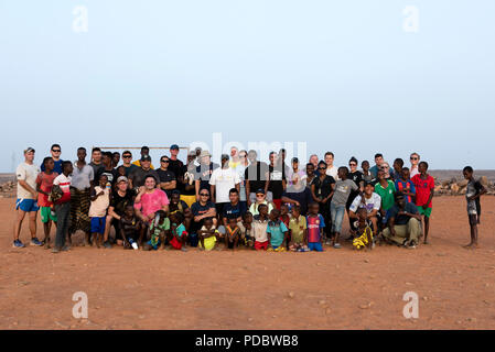 Us-Mitglieder zu Combined Joint Task Force - Horn von Afrika zugeordnet posieren für ein Gruppenfoto mit Kindern aus dem nahe gelegenen Dorf außerhalb von Chebelley Dorf, Dschibuti, Aug 3, 2018. Über 30 Soldaten und Piloten die sich freiwillig für die Öffentlichkeitsarbeit Veranstaltung von der 404Th zivilen Angelegenheiten Bataillon organisiert. (U.S. Air National Guard Foto von Master Sgt. Sarah Mattison) Stockfoto