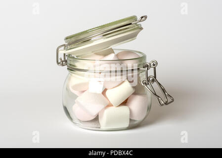 Rosa und weissen Marshmallow Bonbons im Glas Clip top Food storage jar auf weißem Hintergrund Stockfoto