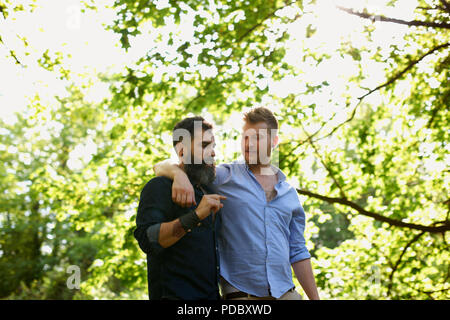 Herzlichen männliche homosexuelle Paare wandern im sonnigen Park Stockfoto