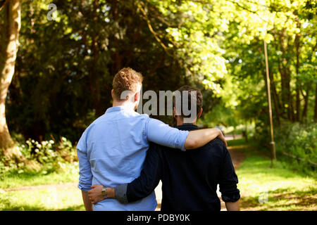 Herzlichen männlichen homosexuellen Paar umarmen, Wandern im sonnigen Park Stockfoto