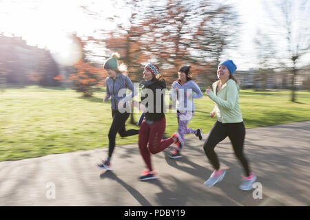 Lächelnd weibliche Läufer im sonnigen Park Stockfoto