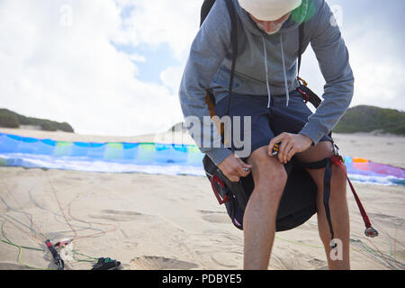 Männliche Gleitschirm Vorbereitung Ausrüstung am Strand