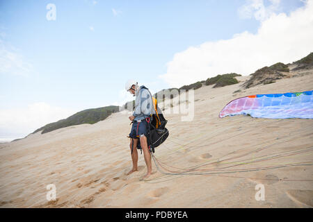 Männliche Gleitschirm Vorbereitung Ausrüstung am Strand
