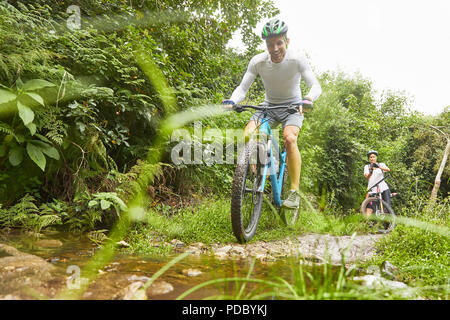 Man Mountainbiken auf schlammigen Weg Stockfoto