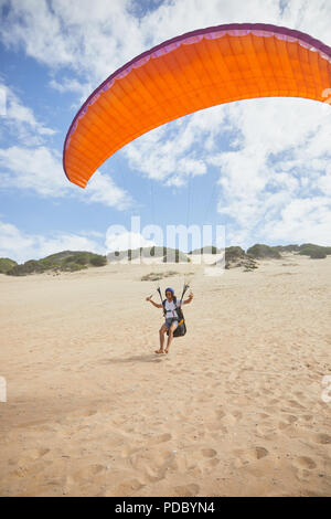 Männliche Gleitschirm mit Fallschirm am Strand Stockfoto