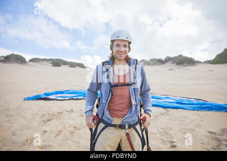 Portrait zuversichtlich männlichen Gleitschirm auf Strand Stockfoto