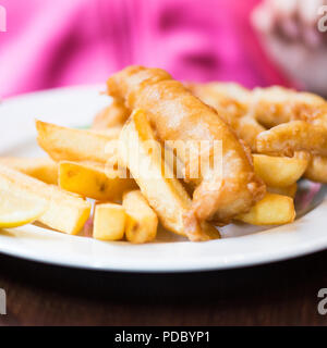 Traditionelle englische Lebensmittel wie Fisch und Chips mit grünen Erbsen in der Kneipe oder im Restaurant serviert. Stockfoto