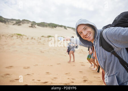 Portrait glückliche, unbeschwerte Menschen am Strand. Stockfoto