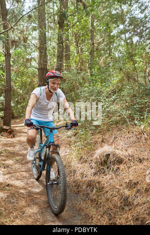 Reifer mann Mountainbiken auf Trail im Wald Stockfoto