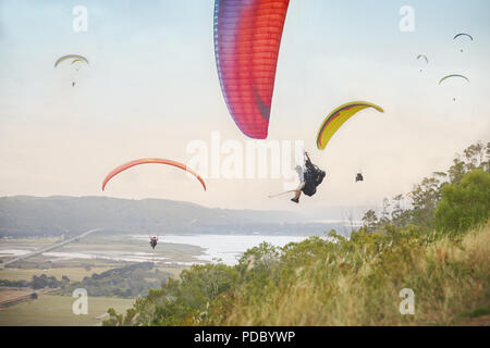 Gleitschirme am Himmel über Landschaft Stockfoto