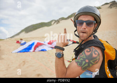 Portrait zuversichtlich, unbeschwerte männlichen Gleitschirm auf Strand Stockfoto