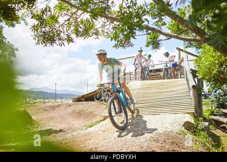 Man Mountainbiken, sonnigen Hindernisparcours Rampe Stockfoto