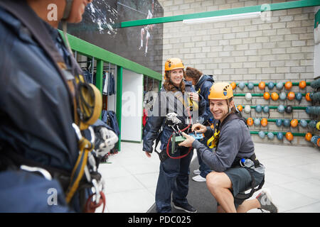 Portrait lächelndes Paar Vorbereitung Zip Line Geräte Stockfoto