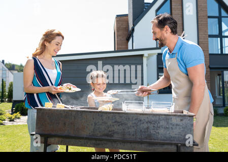 Fröhlicher Mann Fleisch servieren begeistert Stockfoto