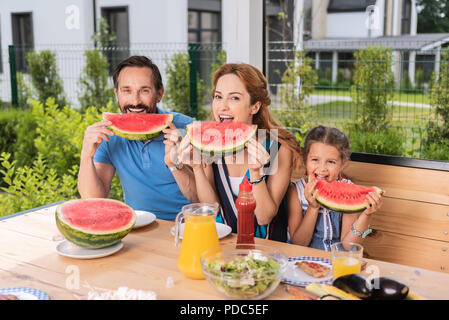 Happy positive Familie Wassermelonen Essen Stockfoto