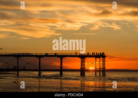 Menschen beobachten Sonnenuntergang von Salburn Victirian's Pier. Saltburn am Meer, North Yorkshire, England. Vereinigtes Königreich. August 2018. Stockfoto