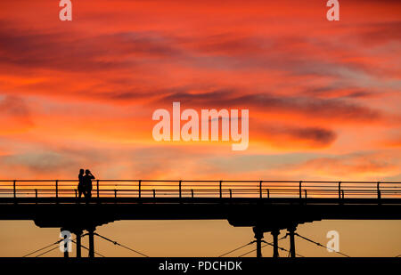 Menschen beobachten Sonnenuntergang von Salburn Victirian's Pier. Saltburn am Meer, North Yorkshire, England. Vereinigtes Königreich. August 2018. Stockfoto