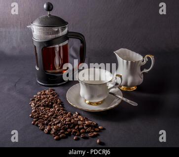 Kaffeetasse, creme Schüssel, Kaffeebereiter und Kaffeebohnen Stockfoto