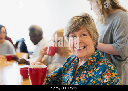 Porträt Lächeln, selbstbewusste ältere Frau trinkt Tee mit Freunden im Community Center Stockfoto