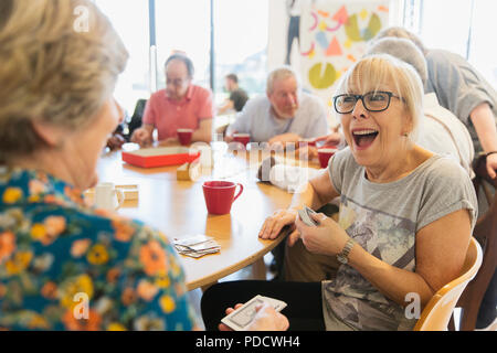 Gerne ältere Frau Spielkarten mit Freund im Community Center Stockfoto