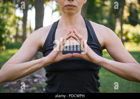 7/8 Bild der Frau zu meditieren und Geste mit den Händen in Park Stockfoto