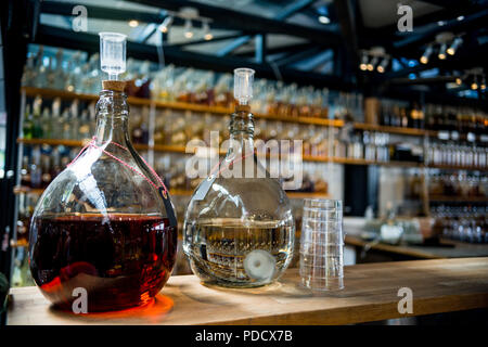 Selektiver Fokus der Jugs mit verschiedenen alkoholischen Getränken auf Theke Stockfoto