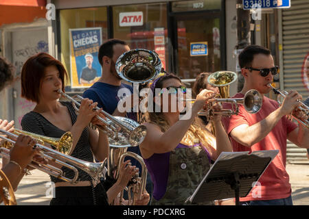 Die 'L-Zug Brass Band" führt unter der Hochbahn auf dem Broadway Bushwick Nachbarschaft von New York während der "Block Party" am Broadway Street Fair am Sonntag, den 5. August 2018. Die Messe, die vom Broadway Merchants Association gesponsert und ist eine Reaktion auf die K2 Epidemie, die der Broadway Flur getätigt hat und bemüht sich, die Menschen zurück zu holen. (Â© Richard B. Levine) Stockfoto