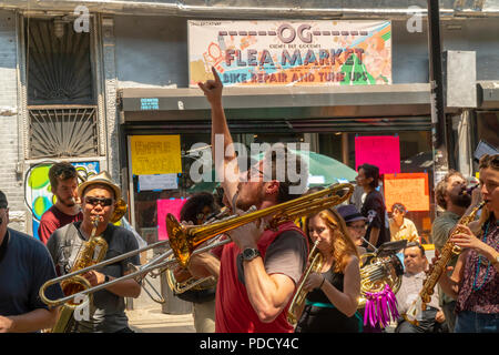 Die 'L-Zug Brass Band" führt unter der Hochbahn auf dem Broadway Bushwick Nachbarschaft von New York während der "Block Party" am Broadway Street Fair am Sonntag, den 5. August 2018. Die Messe, die vom Broadway Merchants Association gesponsert und ist eine Reaktion auf die K2 Epidemie, die der Broadway Flur getätigt hat und bemüht sich, die Menschen zurück zu holen. (Â© Richard B. Levine) Stockfoto