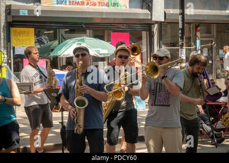 Die 'L-Zug Brass Band" führt unter der Hochbahn auf dem Broadway Bushwick Nachbarschaft von New York während der "Block Party" am Broadway Street Fair am Sonntag, den 5. August 2018. Die Messe, die vom Broadway Merchants Association gesponsert und ist eine Reaktion auf die K2 Epidemie, die der Broadway Flur getätigt hat und bemüht sich, die Menschen zurück zu holen. (© Richard B. Levine) Stockfoto