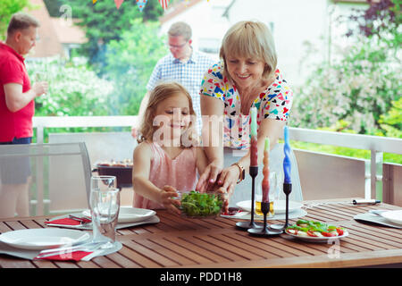 Gerne große Familie Spaß und ihre Gespräche mit Kindern und Enkel genießen Sie beim Grillen auf der Terrasse Stockfoto